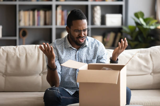 istock Angry irritated African American man dissatisfied by received parcel 1270851174