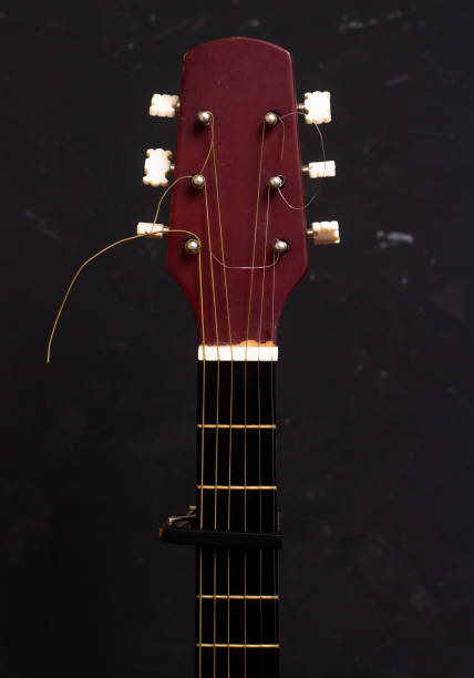 istock Cap on guitar fretboard on black background. Close plan. Wooden guitar. 1270852420