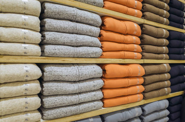 istock Stack of different color shirts on shelves in shop 1270862391