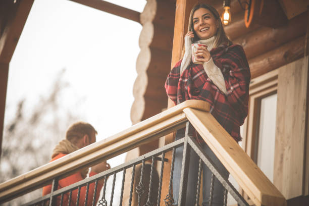 istock Smiling young woman enjoying tea on a patio while talking over the phone 1270868362