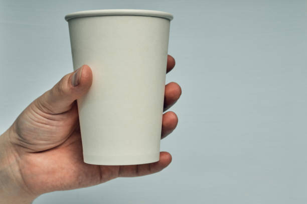 istock Paper cup in hand on a colored background. Eco-friendly materials in a coffee shop, biodegradable disposable tableware. Close up 1270868538