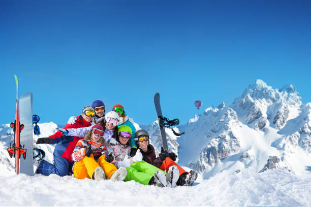 istock Large group of young snowboarders sit in snow 1270868752