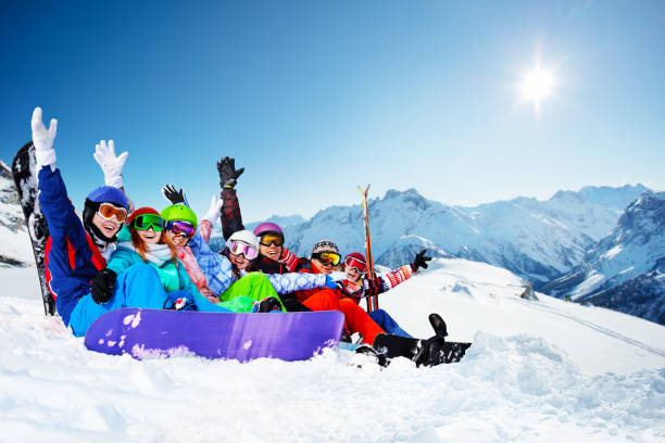 istock Group of young snowboarders sit in snow lift hands 1270868763