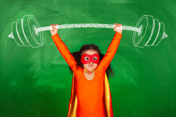 istock Weightlifting superhero girl in front blackboard 1270871429