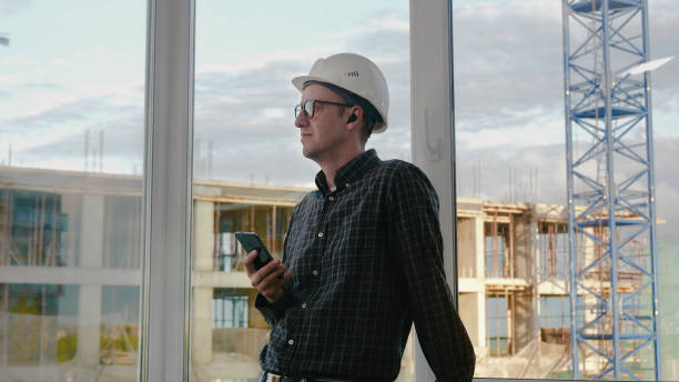 Construction worker listening to music from his phone with wirel
