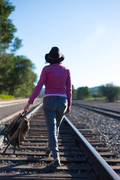 Woman in Pink Walking Down Train Track