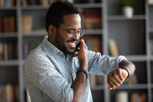 istock Smiling African American man checking time while making phone call 1270879788