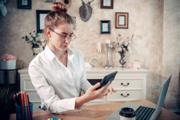 istock Business Entrepreneur Woman is Working on The Desk While Using Calculator for Calculating Marketing Financial in Home Office, Businesswoman Worker Busy Work at Home During Covid-19 Pandemic. 1270879864