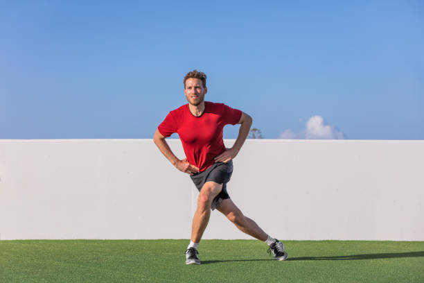 Curtsy lunge exercise fitness man doing body sculpting workout training side thighs muscles with legs lunges at outdoor park gym Curtsy lunge exercise fitness man doing body sculpting workout training side thighs muscles with legs lunges at outdoor park gym. curtseying stock pictures, royalty-free photos & images