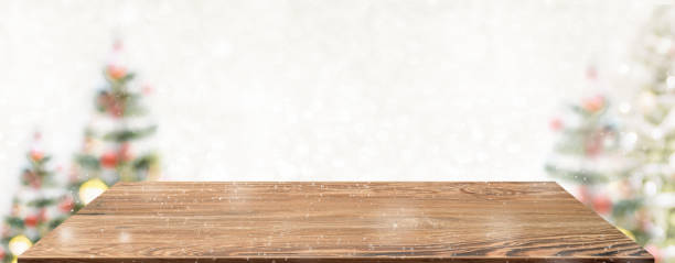 istock Perspective wood table with blur Christmas tree decorate string light and blue bokeh with snow light.Panoramic wooden countertop banner mock up for product display greeting card design online content 1270885988