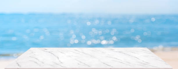 istock summer background.Empty perspective marble table with blur sea and sky bokeh background, banner mockup template for display of product 1270885999