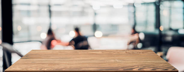 istock Empty wood table with blur people in coffee shop background bokeh light and leaf foreground,Mockup for display or montage of product,Banner for advertise on online media,business presentation 1270886007