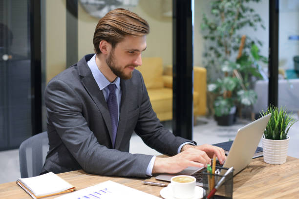 istock Young modern business man working using laptop while sitting in the office. 1270891132