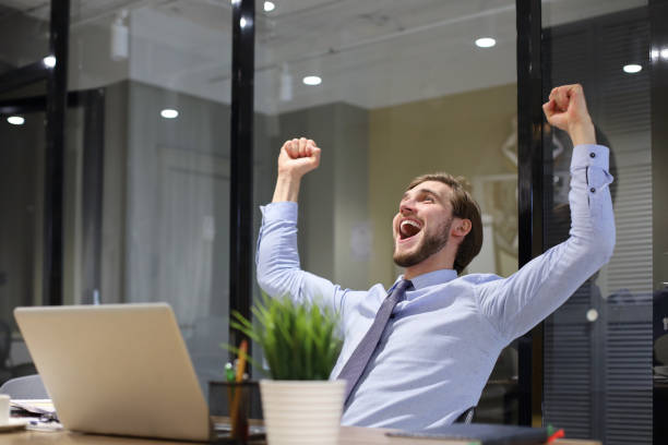 istock Handsome businessman is keeping arms raised and expressing joyful in office. 1270891961