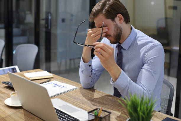 istock Handsome young business man with closed eyes touching face with hands while sitting on working place in office. 1270891991