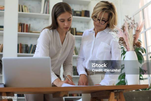 Two Female Collegues Working With Laptop And Discussing New Project Stock Photo - Download Image Now