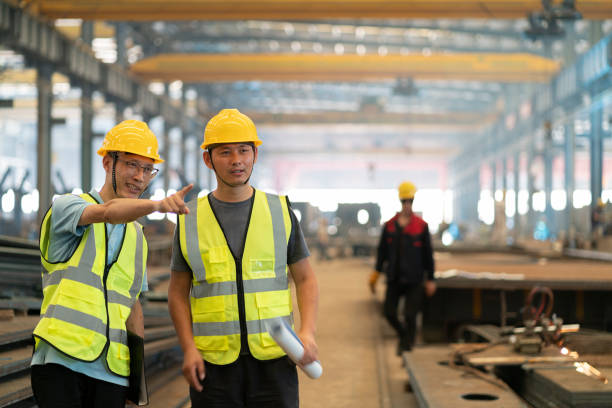 Two Asian male engineers discussing work in the factory