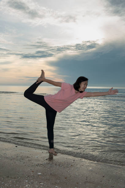 istock healthy woman practicing yoga on the beach 1270898586