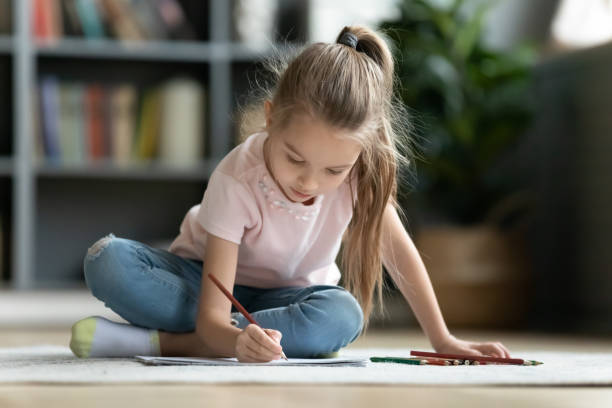 menina bonita brincando no chão quente, desenhando com lápis - school supplies pencil colors apartment - fotografias e filmes do acervo
