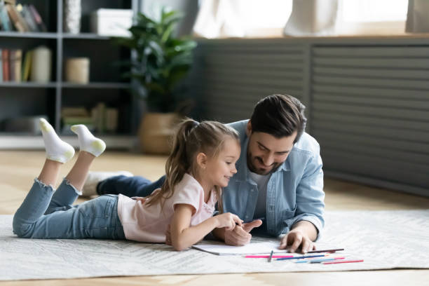 istock Loving father and little daughter drawing with colored pencils 1270899452