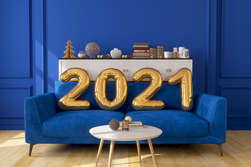 Gold Colored 2021 Year Balloons On The Sofa With Blue Wall.