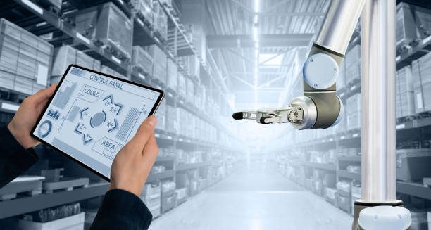 Warehouse manager controls robot arm Warehouse manager with digital tablet controls robot arm remote controlled stock pictures, royalty-free photos & images