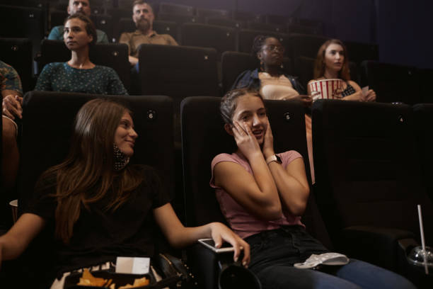 reopening cinema - two girls watching a scary movie - audience surprise movie theater shock imagens e fotografias de stock