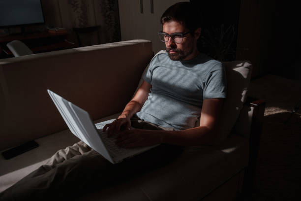 istock Remote Job. Man Working On Laptop Sitting On Sofa At Home 1270905765