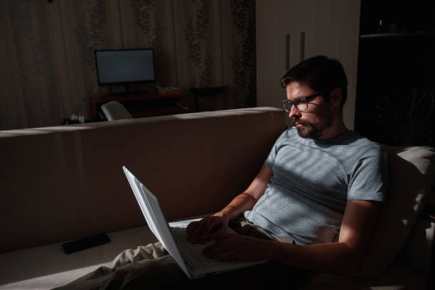 istock Remote Job. Man Working On Laptop Sitting On Sofa At Home 1270906264