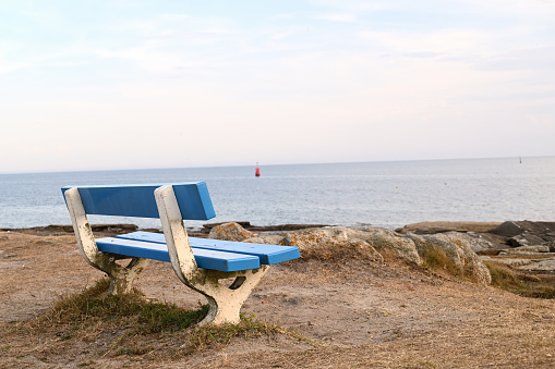 An empty blue bench facing the atlantic ocean in french Brittany
