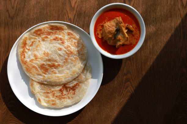 Roti Paratha or Roti Canai with chicken curry sauce stock photo