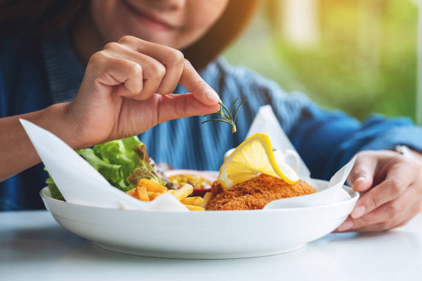 a female chef cooking and decorating a dish of fish and chips