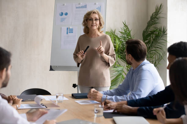 istock Older female leader giving educational lecture in office. 1270913407