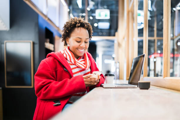 Woman wearing red coat checking he phone.