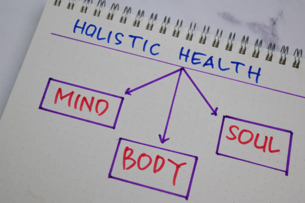 holistic health schreiben auf ein buch mit schlüsselwörtern isoliert holztisch. - geist grafiken stock-fotos und bilder