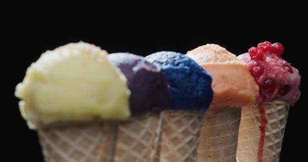 istock Row of multi-colored icecream cones on black background. Close-up 1270919146