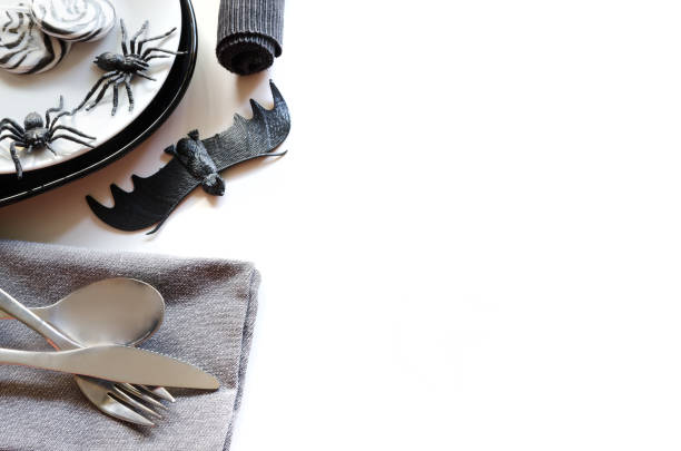 хеллоуин стол настройки аксессуары: черная тарелка службы, белый салат пластины, серебряные столовые приборы и салфетки декоративных паук� - napking ring стоковые фото и изображения