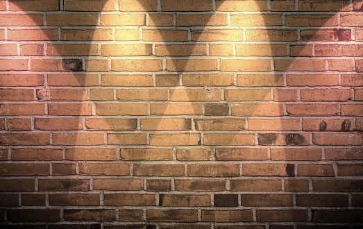 Aged and weathered brick wall textures with bright spotlight illumination