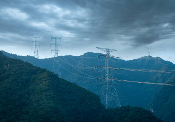 high voltage transmission tower at the mountain - torre de transmissão de eletricidade imagens e fotografias de stock