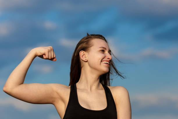 istock Young athletic woman showing her biceps over a blue sky background 1270921320