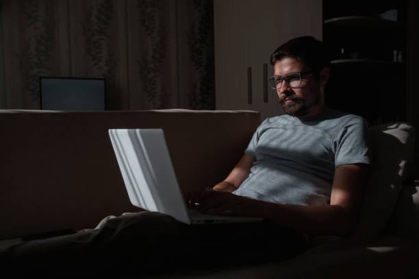 istock Remote Job. Man Working On Laptop Sitting On Sofa At Home 1270922433