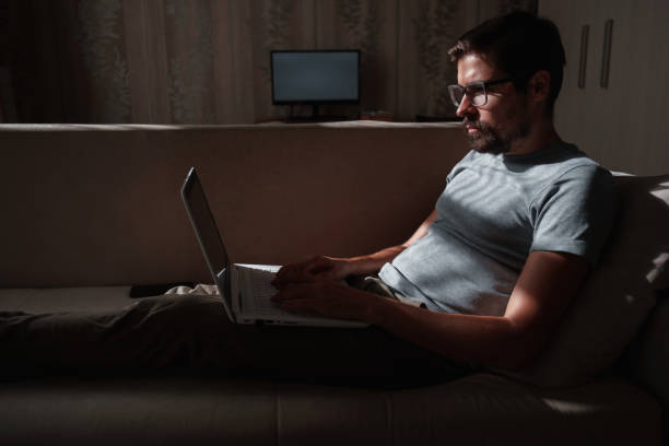 istock Remote Job. Man Working On Laptop Sitting On Sofa At Home 1270922444