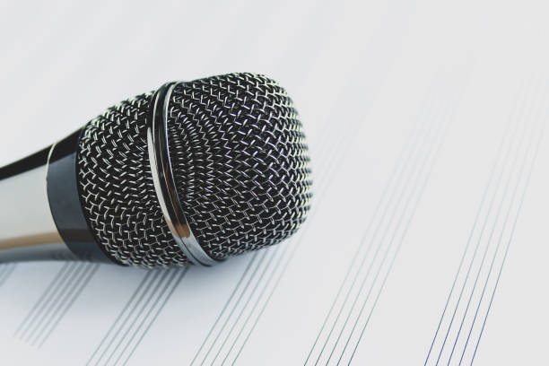 istock Microphone on a blank musical white sheet close up. Singing, writing music, karaoke online, creativity, vocals concept, symbol. Singing lessons 1270923269