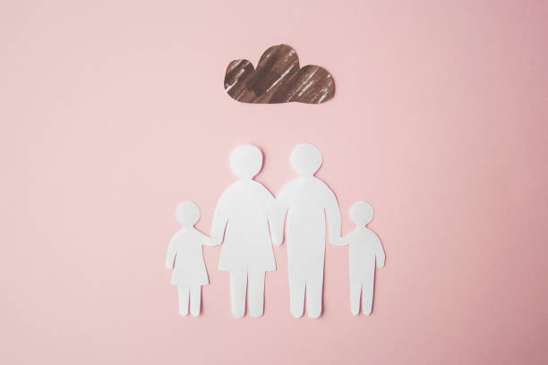 paper family cut out on bright pink background with cloud above, family home, foster care, family mental health, divorce and family crisis concept - couple therapy alternative therapy relationship difficulties imagens e fotografias de stock