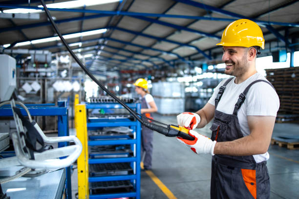 operaio che gestisce una macchina industriale con pulsante joystick. lavorare nel settore delle linee di produzione. - operaio di produzione foto e immagini stock