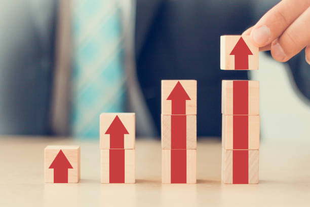 istock business growth go success progress process concept. business man hand arranging wooden cube block with grow up 1270926069