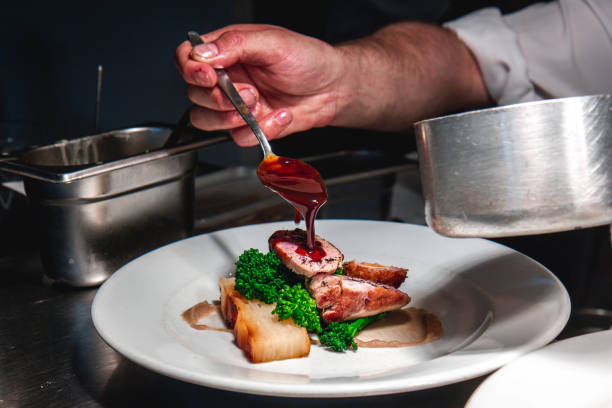 istock chef hand pouring gravy onto roast beef plated food dinner 1270926129
