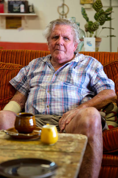 istock Serious senior man looking straight ahead while sitting on a couch in Queensland, Australia 1270926490
