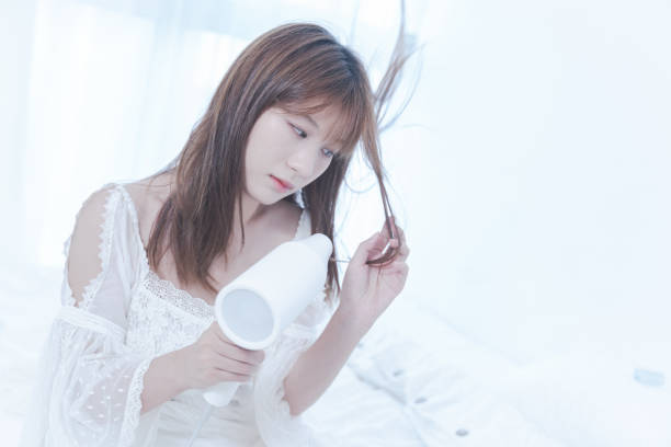 Woman using hair dryer after shower