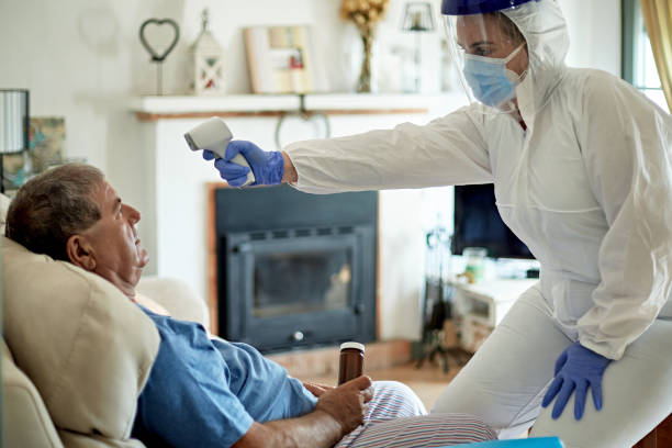 istock Healthcare Worker Using Infrared Thermometer on House Call 1270929335